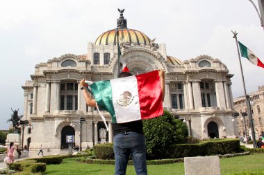 Mexico City, Meksika - 6 Eylül 2023: İnsanlar bağımsızlık ve devrimin ulusal bayramını kutlamak için Palacio de Bellas Artes 'in önünde Meksika bayrağını tutuyor