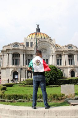 Mexico City, Meksika - 6 Eylül 2023: İnsanlar bağımsızlık ve devrimin ulusal bayramını kutlamak için Palacio de Bellas Artes 'in önünde Meksika bayrağını tutuyor