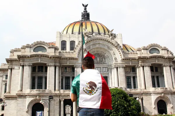 Mexico City, Meksika - 6 Eylül 2023: İnsanlar bağımsızlık ve devrimin ulusal bayramını kutlamak için Palacio de Bellas Artes 'in önünde Meksika bayrağını tutuyor