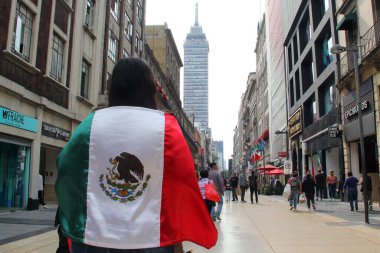 Mexico City, Meksika - 6 Şubat 2023: Kadın, Bağımsızlık ve Devrimi kutlamak için CDMX 'in ocalo' sunda Meksika bayrağını gururla kaldırıyor.