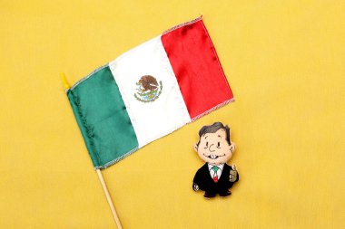 Meksika başkanı şeklindeki pelüş oyuncak Andres Manuel Lopez Obrador AMLO Meksika bayrağını alıyor
