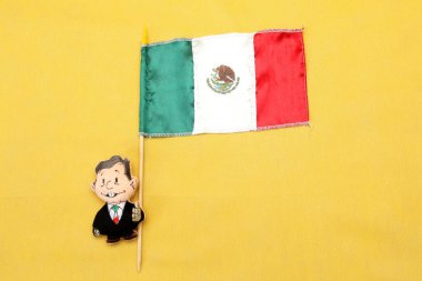 Meksika başkanı şeklindeki pelüş oyuncak Andres Manuel Lopez Obrador AMLO Meksika bayrağını alıyor