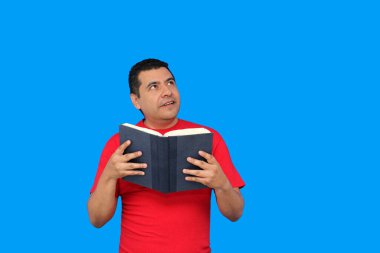 40 yaşında esmer tenli Latin bir adam ders çalışmak ve eğlenmek için kitap okuyor.