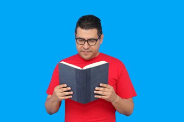 40 yaşında esmer tenli Latin bir adam ders çalışmak ve eğlenmek için kitap okuyor.