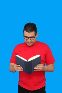 40 yaşında esmer tenli Latin bir adam ders çalışmak ve eğlenmek için kitap okuyor.