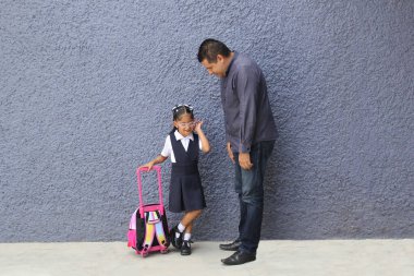 Boşanmış bekar bir baba okula giderken 4 yaşındaki esmer kızıyla birlikte sırt çantasını okula taşır.