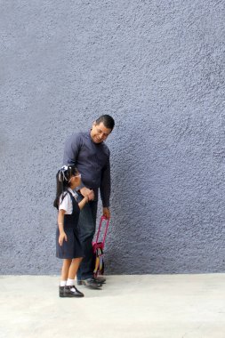 Boşanmış bekar bir baba okula giderken 4 yaşındaki esmer kızıyla birlikte sırt çantasını okula taşır.