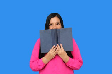 40 yaşındaki Latin kadın hafta sonu tatilinin keyfini çıkarmak ve rahatlamak için ders çalışmak için kitap okuyor.