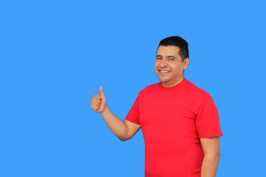 Koyu tenli Latin yetişkin bir adam elini şevkle ve olumlu bir şekilde işareti gösterir.