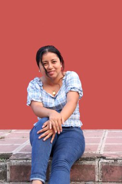 20 yaşındaki genç Latin kadın mutlu ve tatmin olmuş görünüyor. Hayatını özgürlük ve sükunet içinde yaşıyor.