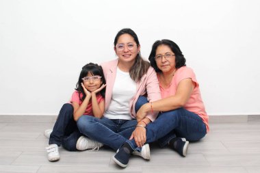 Üç kuşak esmer Latin kadın, büyükanne, anne ve kız gözlüklü birlikte oturup kaliteli zaman geçiriyorlar ve Anneler Günü 'nü kutluyorlar.