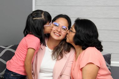 Brunette Latina grandmother, mom and daughter with glasses show their love and support to celebrate Mother's Day clipart