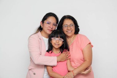 Üç kuşak esmer Latin kadın, büyükanne, anne ve kız gözlüklü. Anneler Günü 'nü kutluyorlar.