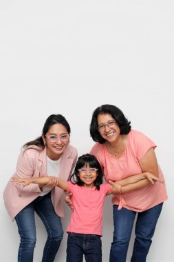 Üç kuşak esmer Latin kadın, büyükanne, anne ve kız gözlüklü. Anneler Günü 'nü kutluyorlar.