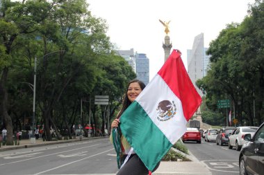 40 yaşındaki Latin kadın, Bağımsızlık Günü ve Cinco de Mayo 'yu kutlamak için Meksika sokaklarında Meksika bayrağını gururla sergiliyor.
