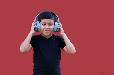 9 yaşında kahverengi Latin bir çocuk. Otizm spektrum bozukluğu, dikkat eksikliği ve yüksek seslere duyarlılık için ses yalıtımlı kulaklıkları var.