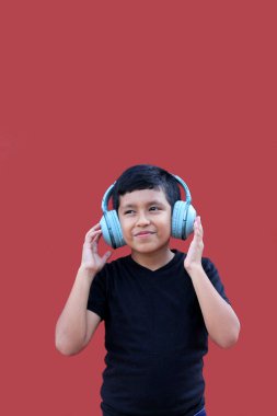 9 yaşında kahverengi Latin bir çocuk. Otizm spektrum bozukluğu, dikkat eksikliği ve yüksek seslere duyarlılık için ses yalıtımlı kulaklıkları var.