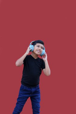 9 yaşında kahverengi Latin bir çocuk. Otizm spektrum bozukluğu, dikkat eksikliği ve yüksek seslere duyarlılık için ses yalıtımlı kulaklıkları var.