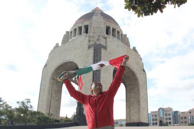 Latin yetişkin adam Bağımsızlık Günü 'nü ve Cinco de Mayo' yu kutlamak için Meksika bayrağını gururla Meksika sokaklarında sergiliyor.