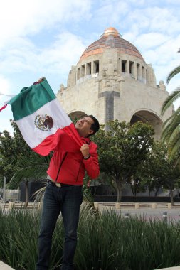 Latin yetişkin adam Bağımsızlık Günü 'nü ve Cinco de Mayo' yu kutlamak için Meksika bayrağını gururla Meksika sokaklarında sergiliyor.