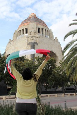 Latin yetişkin kadın Meksika Bağımsızlık Günü ve Cinco de Mayo bayramını kutlamak için Meksika bayrağını gururla gösteriyor.