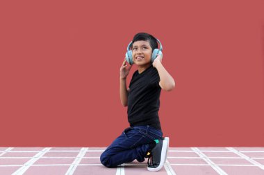 9 yaşındaki esmer tenli Latin çocuk otizm için gürültü yalıtımlı kulaklık kullanıyor, yalnızlık içinde sakinleşiyor, Asperger sendromunu kontrol ediyor.