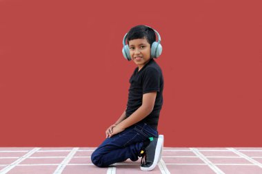 9 yaşındaki esmer tenli Latin çocuk otizm için gürültü yalıtımlı kulaklık kullanıyor, yalnızlık içinde sakinleşiyor, Asperger sendromunu kontrol ediyor.