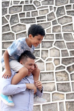 Boşanmış bekar bir baba, 9 yaşındaki koyu tenli Latin oğlunu omuzlarında taşır. Babalar Günü 'nü birlikte geçirir ve oynar.