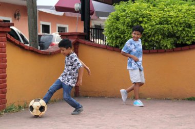 9 yaşındaki fakir, koyu tenli iki Latin çocuk sokakta futbol oynuyor. Yoksulluk içinde mutlu bir çocukluk geçiriyorlar.