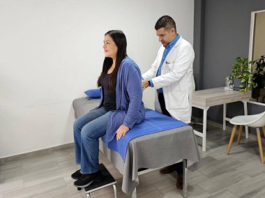 Erkek, esmer doktor, travma uzmanı. Latin kadın hastaları muayene ediyor.