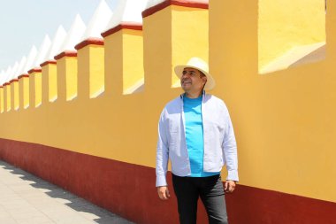 Latin Amerika 'nın taşralı bir kasabasının sokaklarında gezen 40 yaşındaki esmer tenli Latin bir adam, gezerken ve keşfederken,