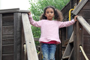 4 yaşındaki esmer ve kıvırcık saçlı Latin kız, dikkat eksikliği hiperaktivite bozukluğu tedavisi ve terapisi için açık hava oyunları oynuyor.