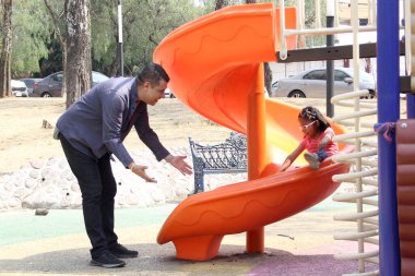 Boşanmış bekar baba ve 5 yaşındaki esmer Latin kızı park oyunlarında oynuyorlar ve dışarıda kaliteli zaman geçiriyorlar.