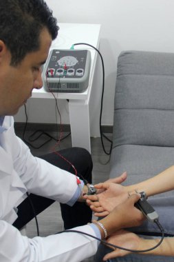 Koyu tenli Latin nörolog, elektromiyografi ve somatosensoriyel potansiyel çalışma yapıyor.