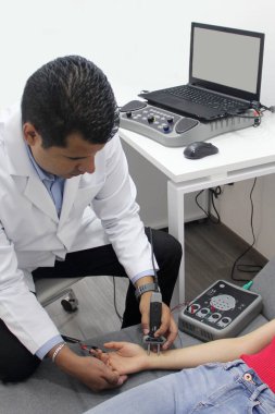 Dark-skinned Latino neurologist specialist doctor performs electromyography and somatosensory evoked potential study on arm and hand clipart