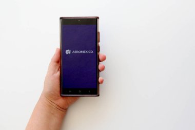 Mexico City, Mexico - 22 Şubat 2025: Aeromexico Havayolları 'nın seyahat biletlerinizi ayırtmak ve giriş kartınızı almak için cep telefonu ve bilgisayar başvurusu