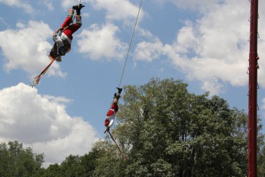 Mexico City, Meksika - 2 Ağustos 2023 Voladores de Papantla, Veracruz 'daki İspanyol ayininden önce iplerle bağlanmış yüksek bir direkten boşluğa atlayan bir grup dansçı.