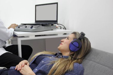 İşitsel uyarı potansiyelleri, işitme cihazları olan 30 yaşındaki bir kadın üzerinde yapılan nörofizyolojik bir test işitsel sistemin işlevini değerlendiriyor. 