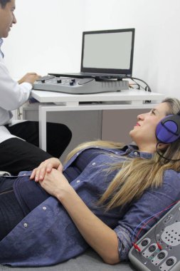 İşitsel uyarı potansiyelleri, işitme cihazları olan 30 yaşındaki bir kadın üzerinde yapılan nörofizyolojik bir test işitsel sistemin işlevini değerlendiriyor. 