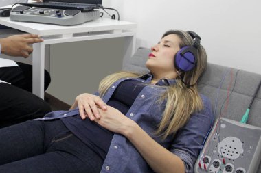 İşitsel uyarı potansiyelleri, işitme cihazları olan 30 yaşındaki bir kadın üzerinde yapılan nörofizyolojik bir test işitsel sistemin işlevini değerlendiriyor. 