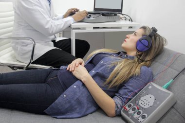 İşitsel uyarı potansiyelleri, işitme cihazları olan 30 yaşındaki bir kadın üzerinde yapılan nörofizyolojik bir test işitsel sistemin işlevini değerlendiriyor. 