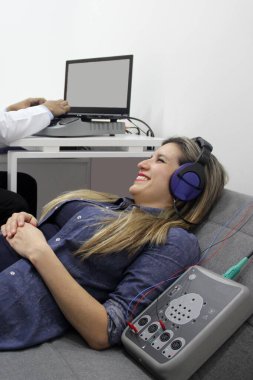 İşitsel uyarı potansiyelleri, işitme cihazları olan 30 yaşındaki bir kadın üzerinde yapılan nörofizyolojik bir test işitsel sistemin işlevini değerlendiriyor. 