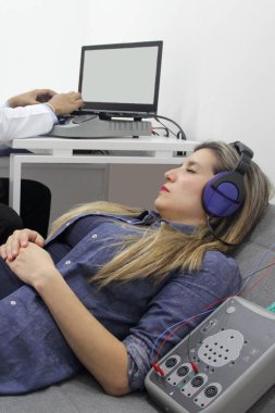 İşitsel uyarı potansiyelleri, işitme cihazları olan 30 yaşındaki bir kadın üzerinde yapılan nörofizyolojik bir test işitsel sistemin işlevini değerlendiriyor. 