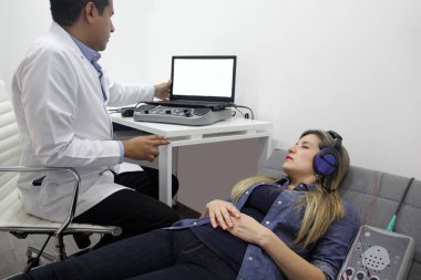 İşitsel uyarı potansiyelleri, işitme cihazları olan 30 yaşındaki bir kadın üzerinde yapılan nörofizyolojik bir test işitsel sistemin işlevini değerlendiriyor. 