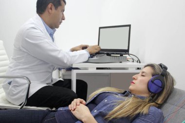 İşitsel uyarı potansiyelleri, işitme cihazları olan 30 yaşındaki bir kadın üzerinde yapılan nörofizyolojik bir test işitsel sistemin işlevini değerlendiriyor. 