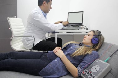 İşitsel uyarı potansiyelleri, işitme cihazları olan 30 yaşındaki bir kadın üzerinde yapılan nörofizyolojik bir test işitsel sistemin işlevini değerlendiriyor. 