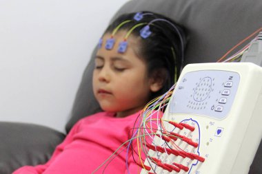 Elektroensefalogram, beynin elektriksel aktivitesini ölçen 5 yaşındaki Latin bir kızın beyin dalgalarını kaydederek otizm veya hiperaktivite teşhisi koyan bir test.