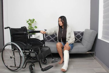 30 yaşında, bacağı kırılan esmer Latin bir kadın. Hareket etmek için tekerlekli sandalye kullanıyor.