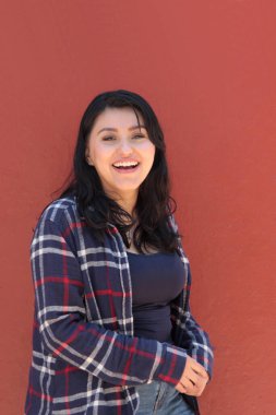 25 yaşında bekar bir Latin kadın, kişisel ve profesyonel başarılarla dolu mutlu bir hayattan güç alarak gülümsüyor.