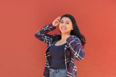 25 yaşında bekar bir Latin kadın, kişisel ve profesyonel başarılarla dolu mutlu bir hayattan güç alarak gülümsüyor.